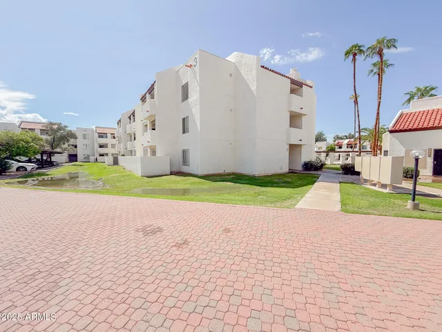 a view of a house with a yard and a car park