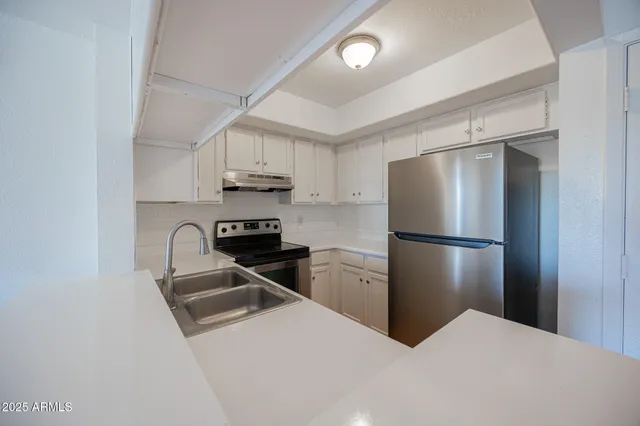 a kitchen with stainless steel appliances a refrigerator sink and stove