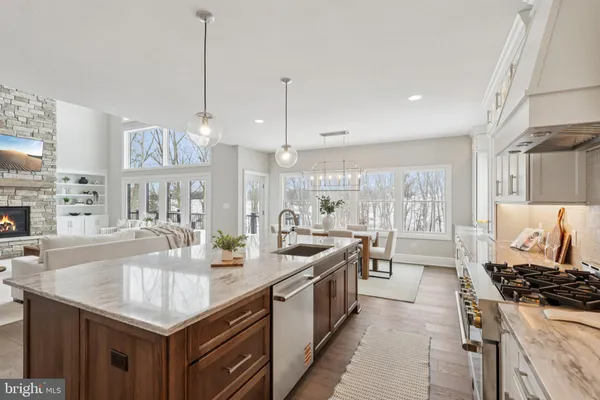 a kitchen with stainless steel appliances granite countertop a sink a stove and a wooden floors