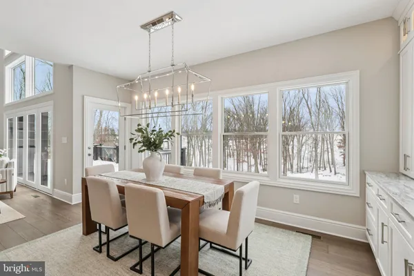 a dining room with furniture a chandelier and wooden floor