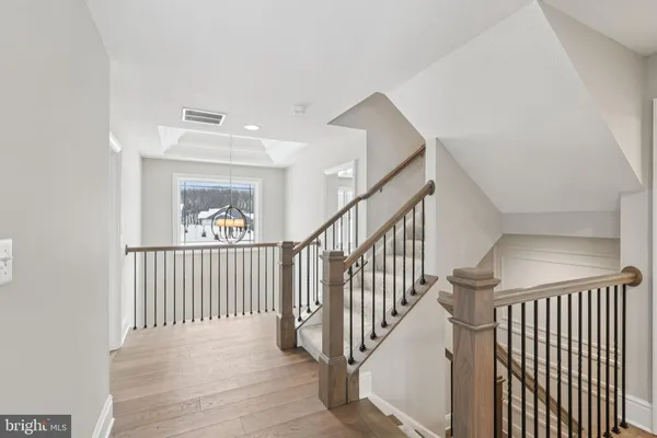 a view of staircase with railing and white walls