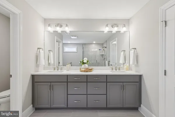 a bathroom with a granite countertop sink a toilet and shower