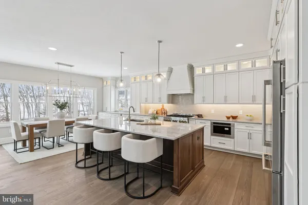 a kitchen with a dining table chairs stove and white cabinets