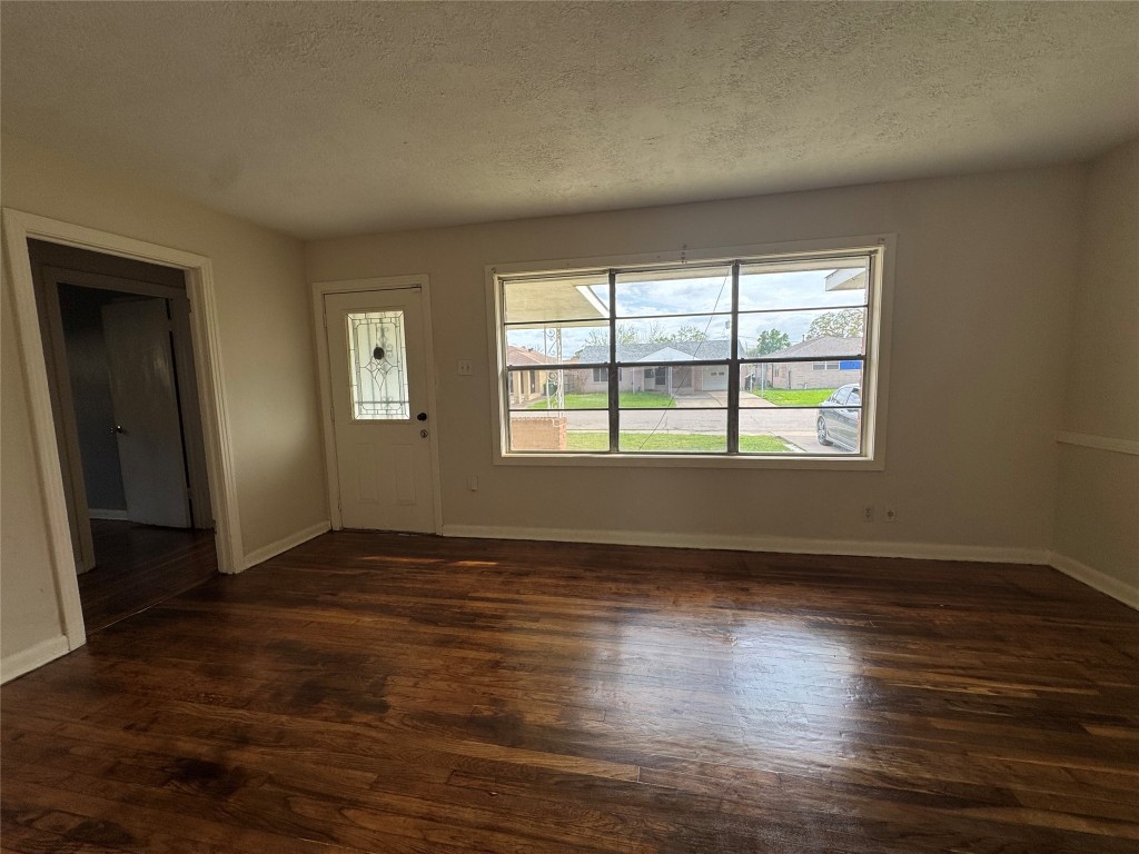 8719 Tilgham Street Houston, TX 77029 - Photo 3 of 11 an empty room with wooden floor and windows