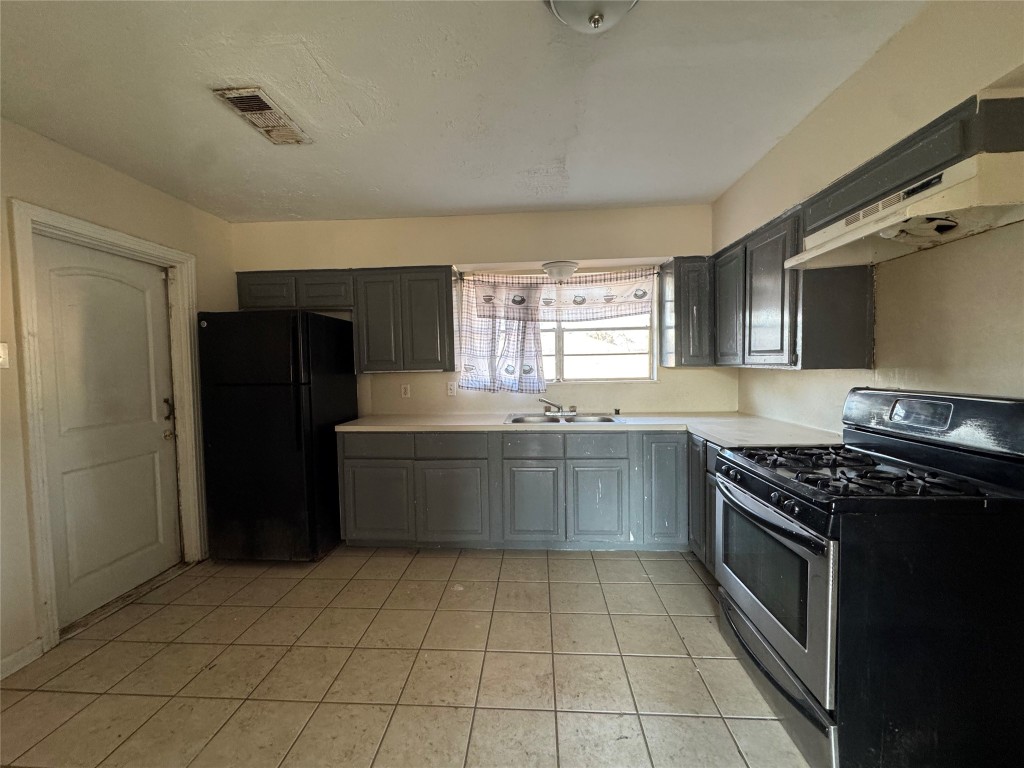 8719 Tilgham Street Houston, TX 77029 - Photo 4 of 11 a kitchen with a stove sink and cabinets