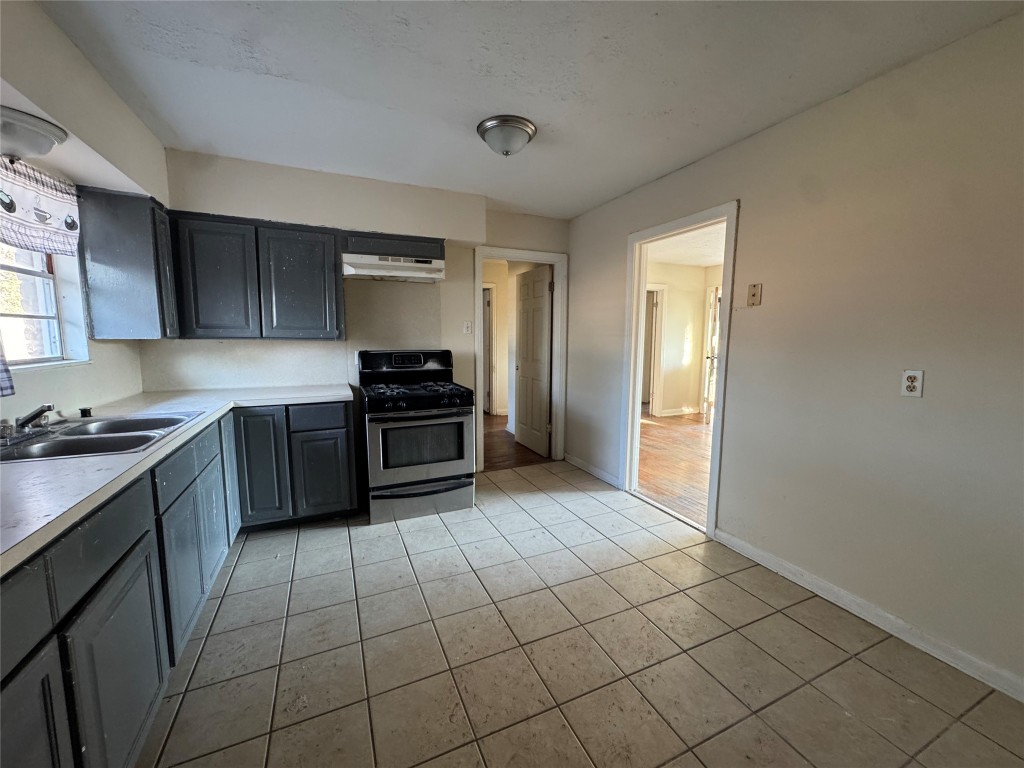 8719 Tilgham Street Houston, TX 77029 - Photo 5 of 11 a kitchen with stainless steel appliances granite countertop a stove refrigerator and sink