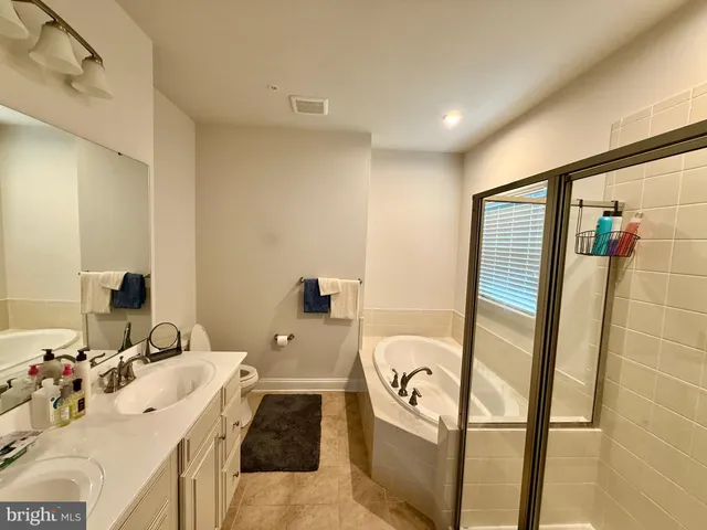 a bathroom with a sink mirror and tub