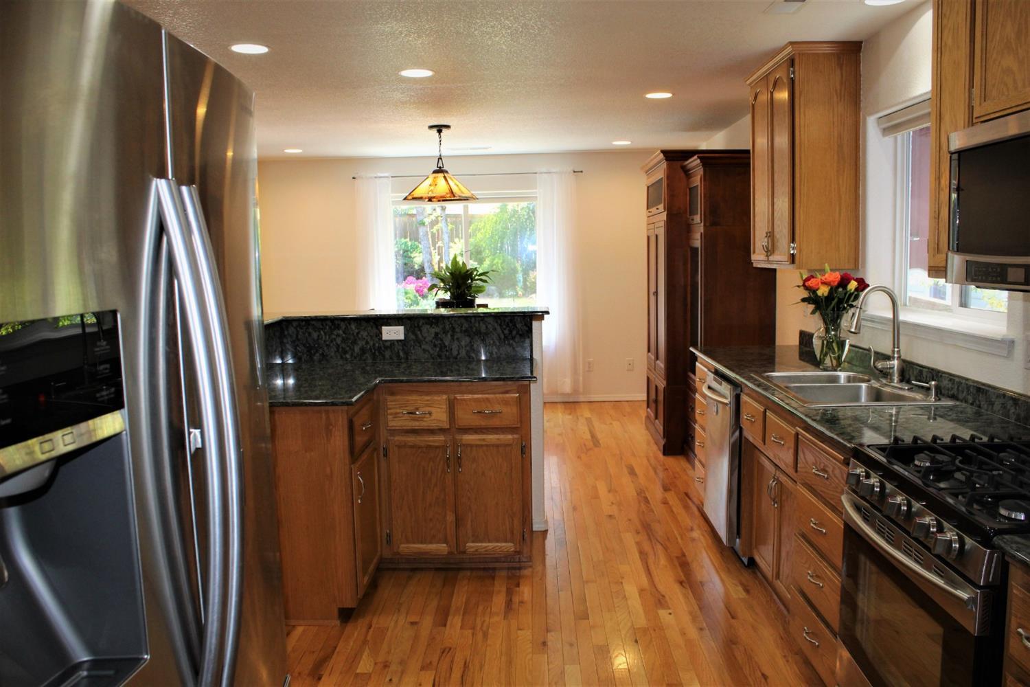 1246 Poppy Ridge Drive Eagle Point, OR 97524 - Photo 8 of 34 a kitchen with stainless steel appliances granite countertop a refrigerator a stove and a sink