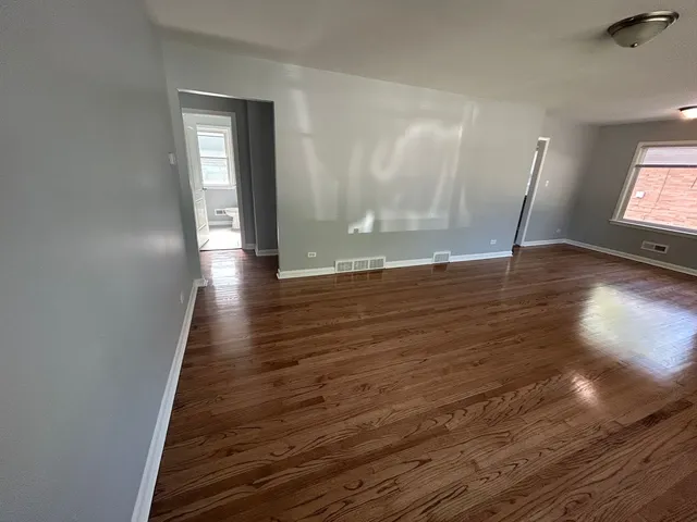 a view of a room with wooden floor and window