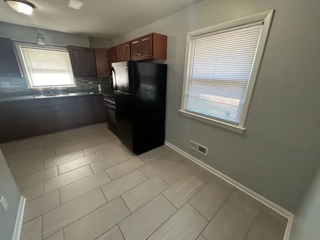 a kitchen with granite countertop a refrigerator and window