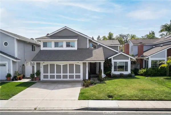 a house view with a garden and large trees