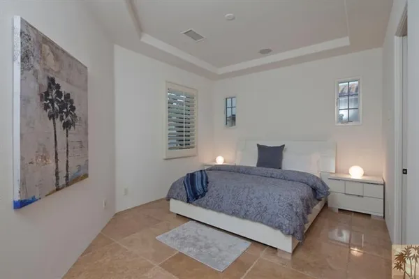 a living room with stainless steel appliances furniture a flat screen tv and kitchen view