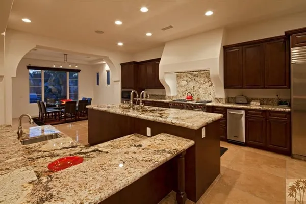 a kitchen with kitchen island granite countertop wooden cabinets and a sink