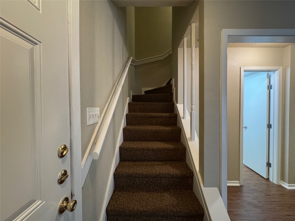 4904 West Wind Trail, Unit 103 Austin, TX 78745 - Photo 11 of 22 a view of staircase with wooden floor and white walls