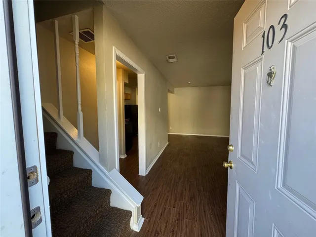 a view of a hallway with wooden floor and staircase