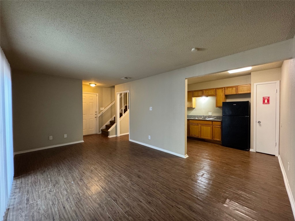 4904 West Wind Trail, Unit 103 Austin, TX 78745 - Photo 3 of 22 a view of empty room with wooden floor and kitchen