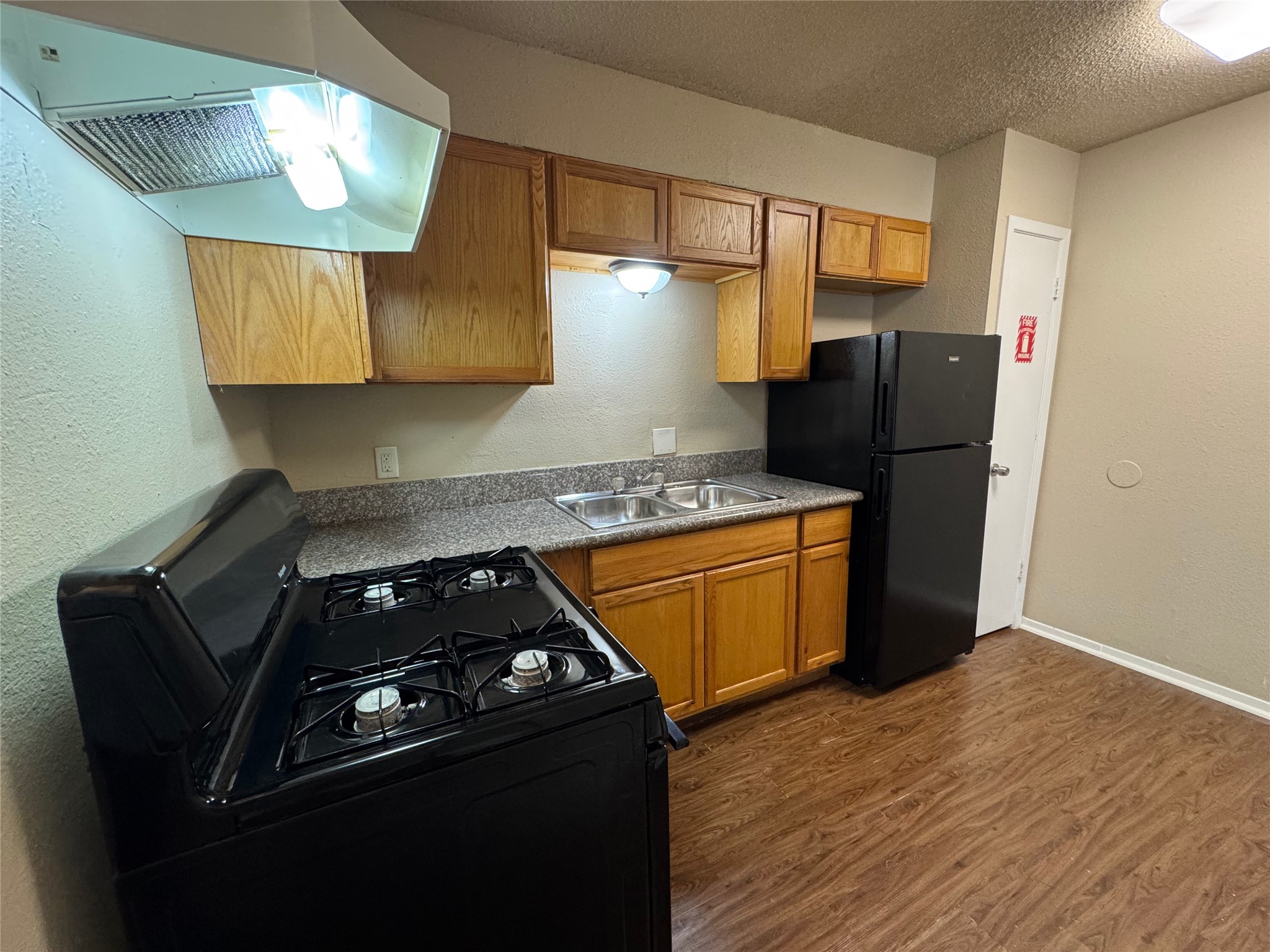 4904 West Wind Trail, Unit 103 Austin, TX 78745 - Photo 6 of 22 a kitchen with stainless steel appliances granite countertop a stove a sink and a refrigerator