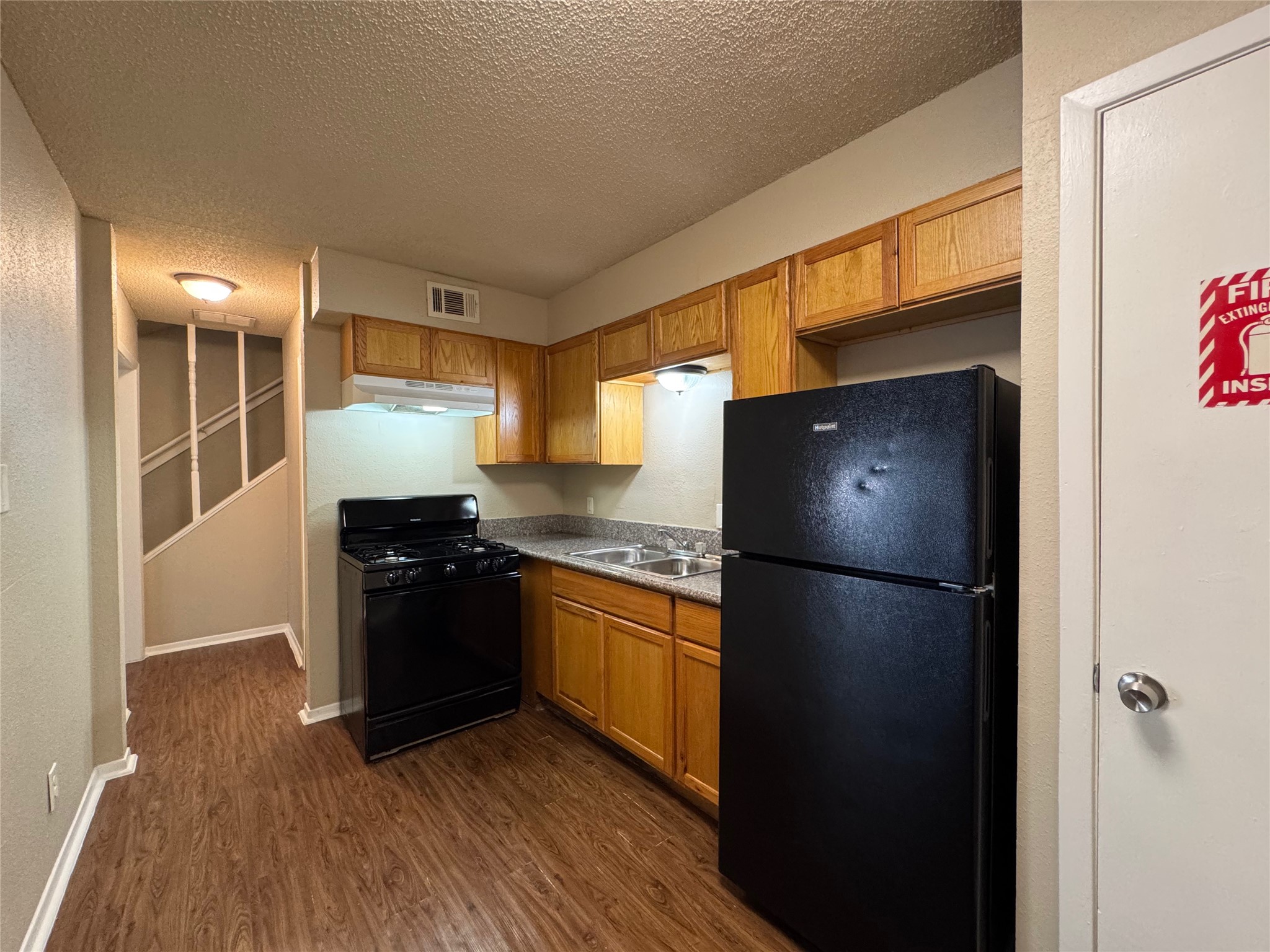 4904 West Wind Trail, Unit 103 Austin, TX 78745 - Photo 7 of 22 a kitchen with a refrigerator and a stove top oven