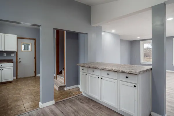 a kitchen with granite countertop white cabinets and white appliances