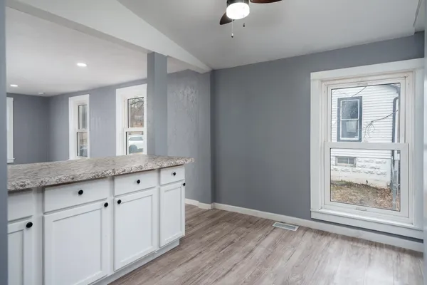 an empty room with wooden floor and windows
