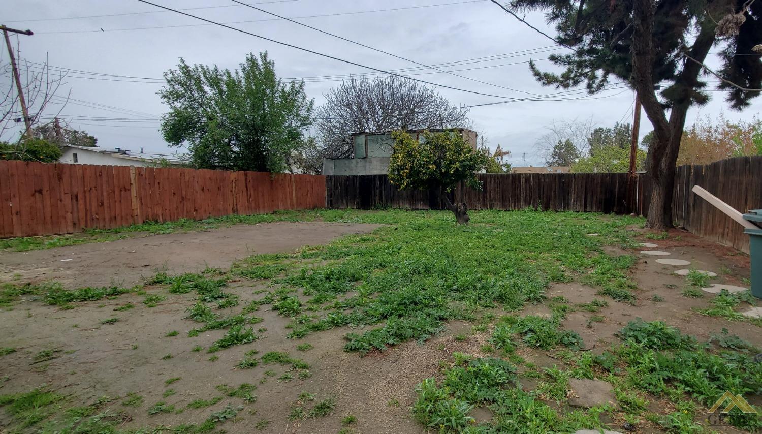 Undisclosed Address Wasco, CA 93280 - Photo 12 of 12 a view of a backyard with potted plants and wooden fence