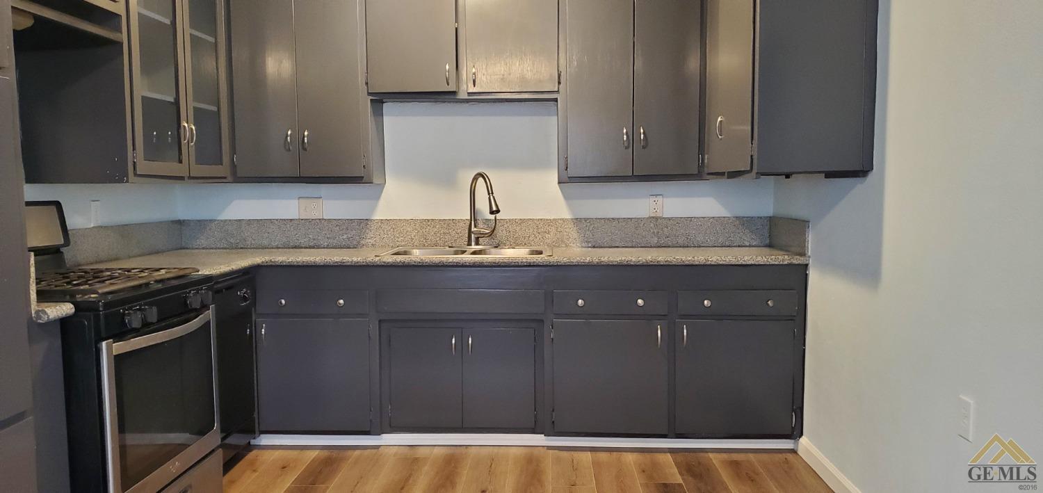 Undisclosed Address Wasco, CA 93280 - Photo 3 of 12 a kitchen with granite countertop a cabinets sink and stove
