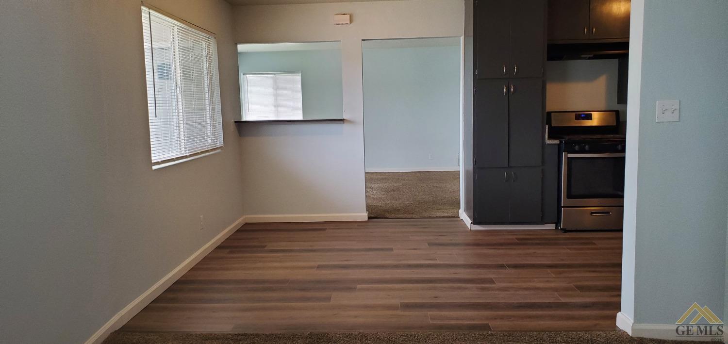 Undisclosed Address Wasco, CA 93280 - Photo 5 of 12 a view of an empty room with wooden floor and a window