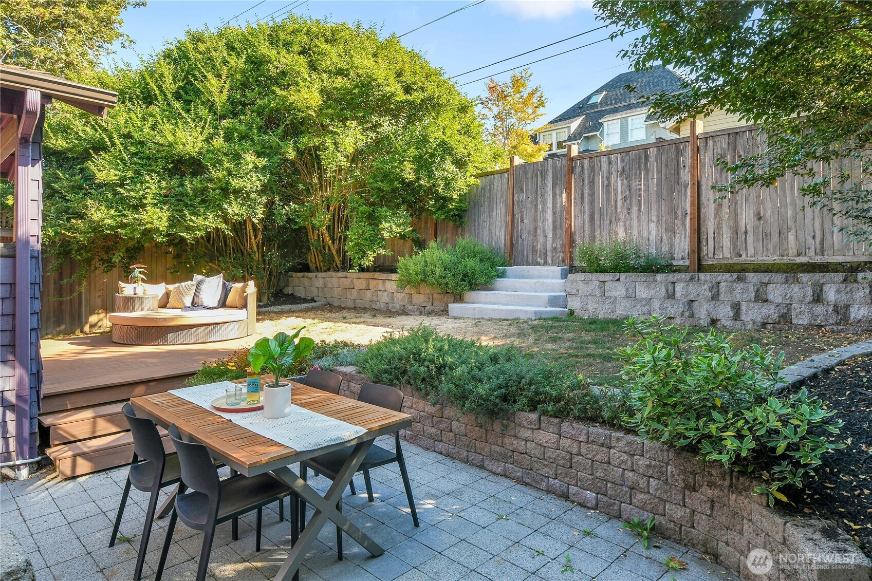 916 20th Avenue East Seattle, WA 98112 - Photo 12 of 28 a view of a backyard with table and chairs with wooden fence and plants