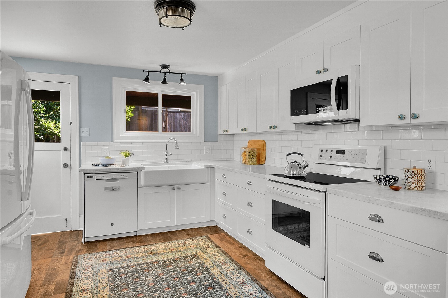 916 20th Avenue East Seattle, WA 98112 - Photo 7 of 28 a kitchen with stainless steel appliances white cabinets and a sink