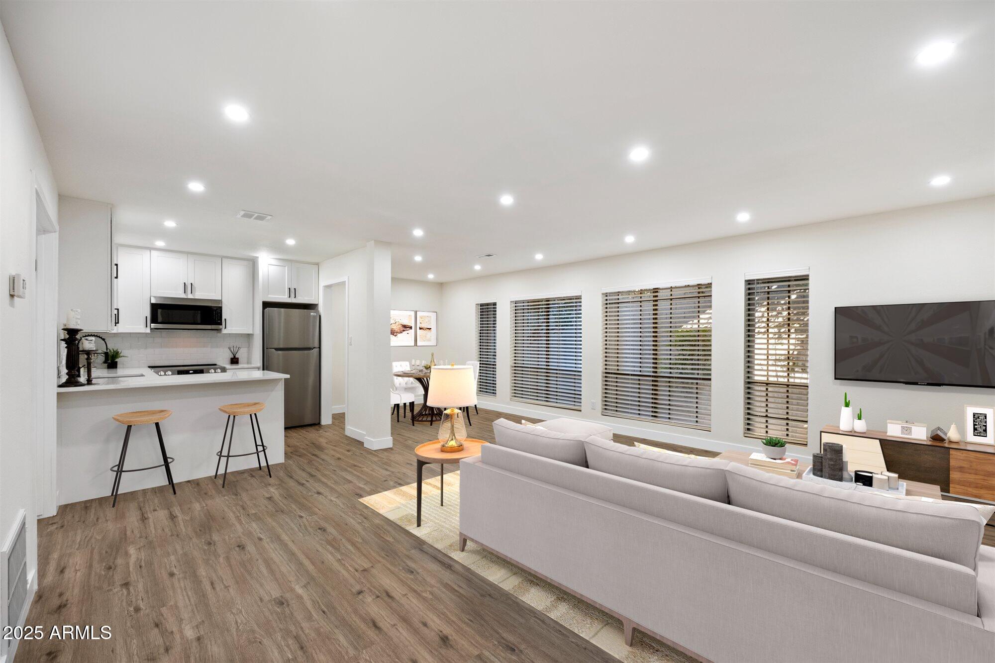 a living room with furniture flat screen tv and large window