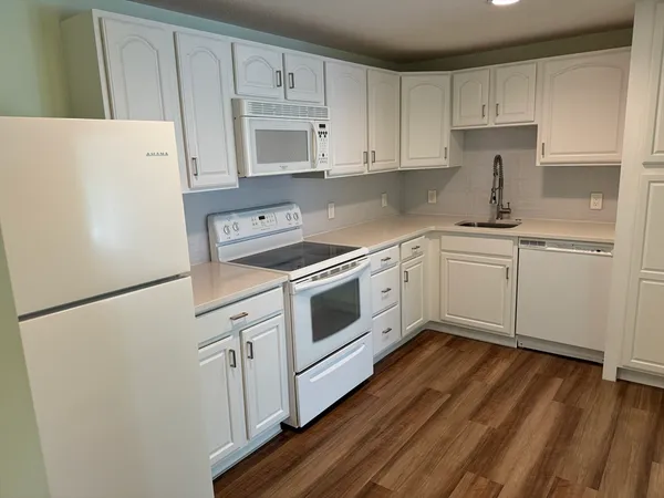 a kitchen with a white cabinets and white appliances