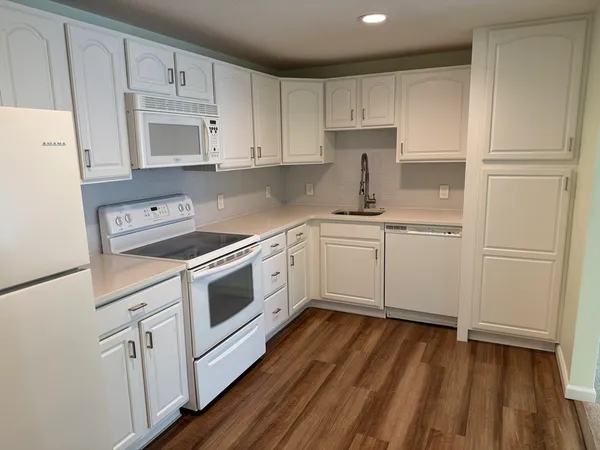 a kitchen with white cabinets stainless steel appliances and sink