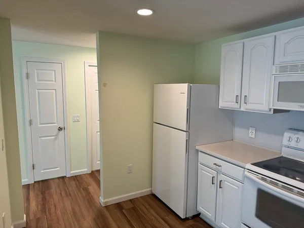 a view of a kitchen with sink and refrigerator