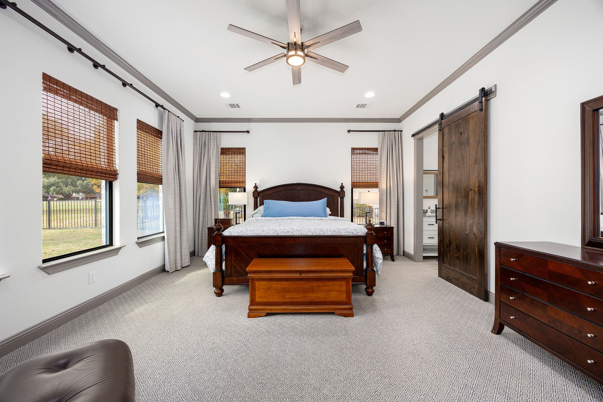 86 Dawns Edge Conroe, TX 77356 - Photo 18 of 50 A spacious primary suite includes a barn door leading to the ensuite bathroom and electric curtains for effortless light control.