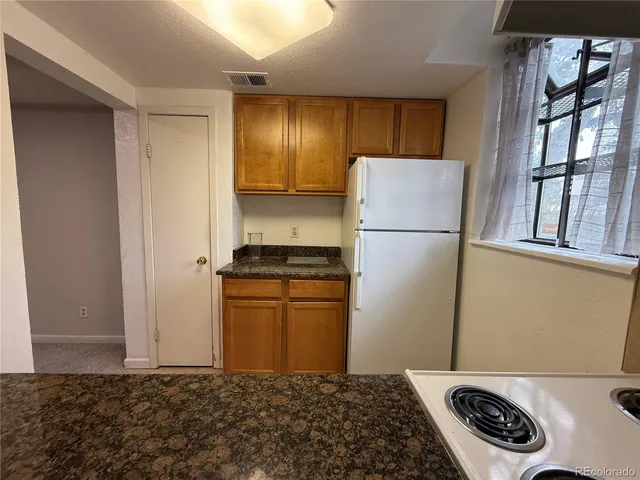a kitchen with a refrigerator and a stove