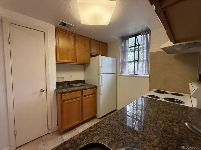 a kitchen with granite countertop cabinets and refrigerator