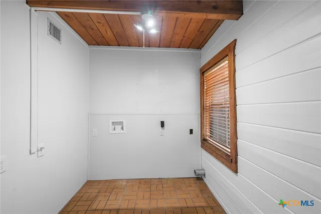 a view of a big room with wooden floor and windows