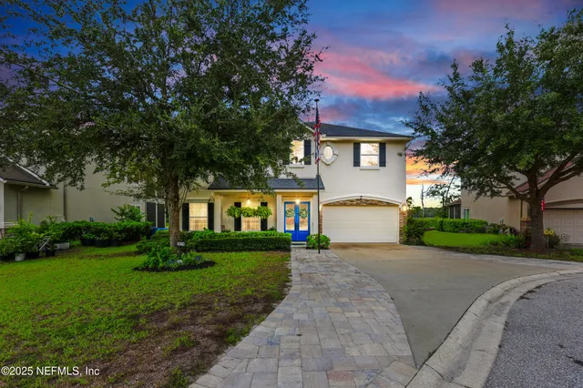 a front view of a house with a yard and trees