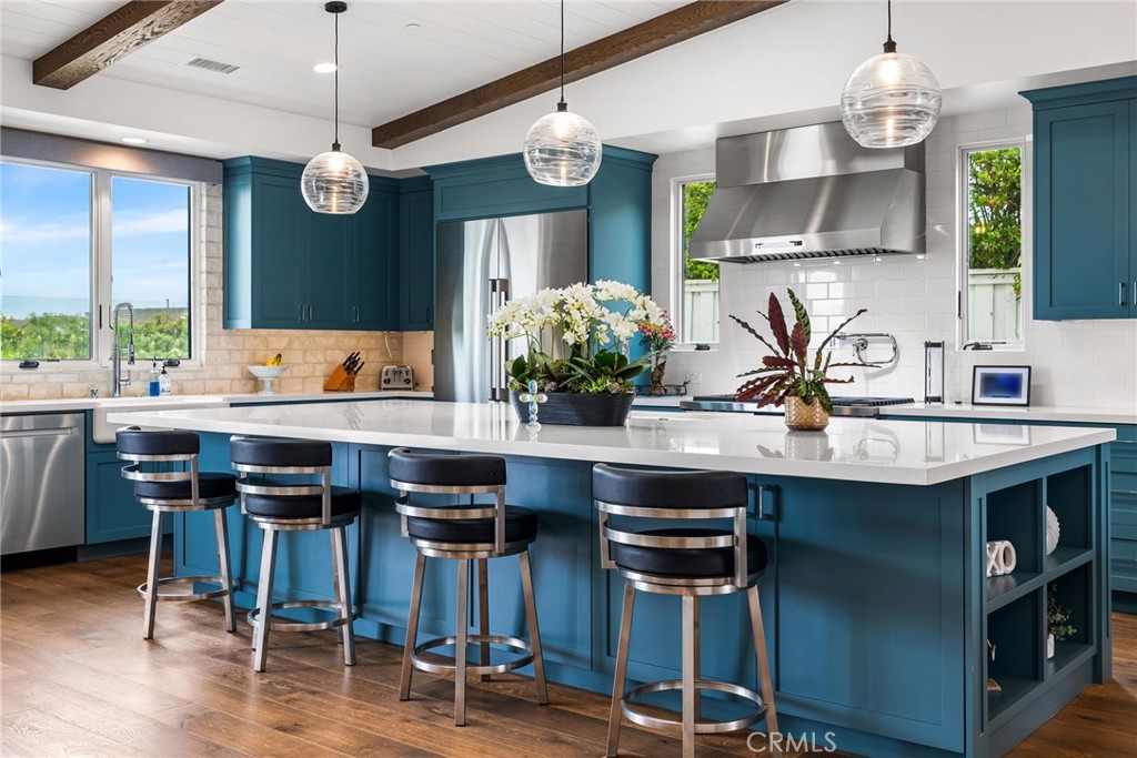1231 Sand Key Corona del Mar, CA 92625 - Photo 4 of 65 a kitchen with stainless steel appliances a dining table chairs and wooden floor