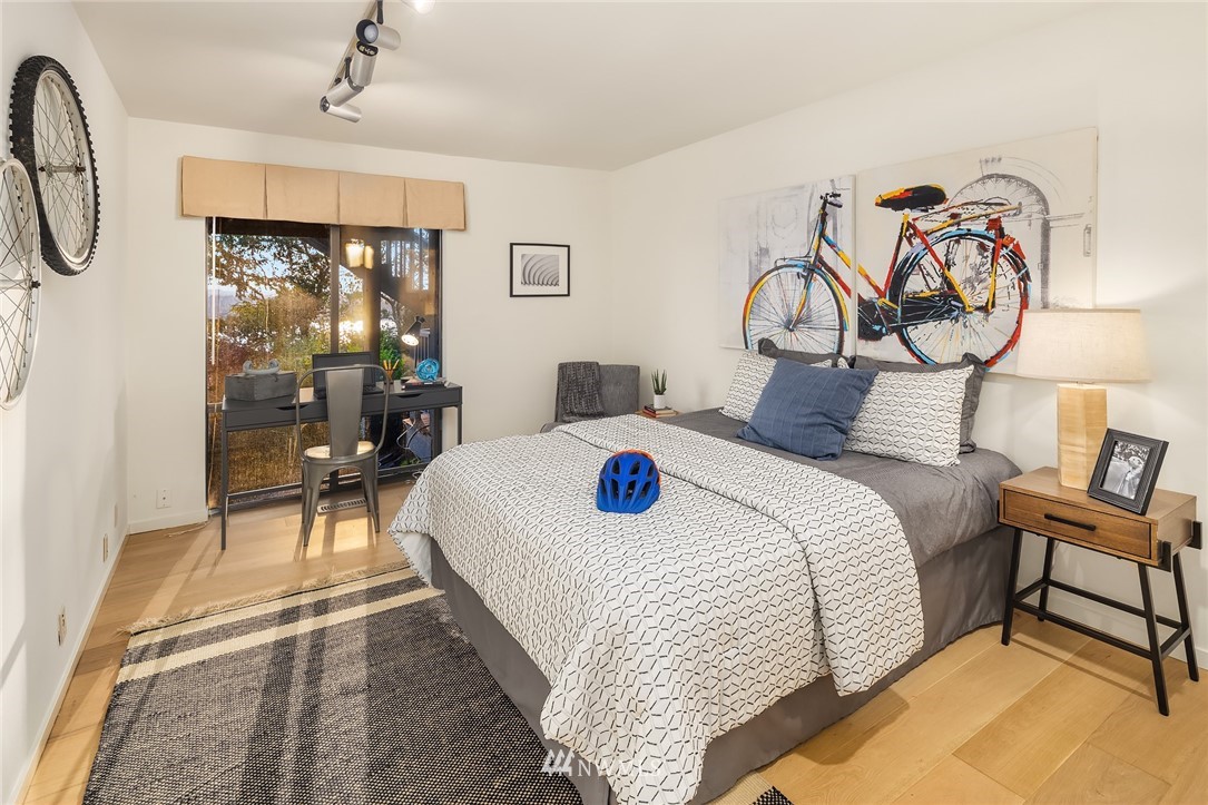 7701 Ridgecrest Lane Mercer Island, WA 98040 - Photo 24 of 35 a bedroom with a bed a table and painting on the wall