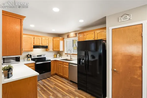 a kitchen with a refrigerator and a stove top oven