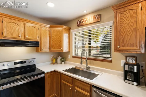 a kitchen with granite countertop a sink stove and cabinets