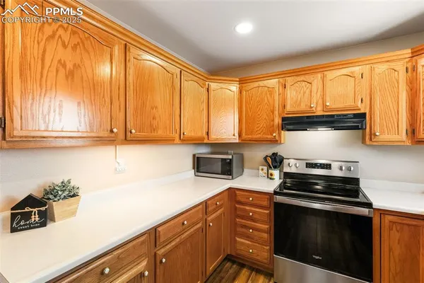 a kitchen with granite countertop cabinets stainless steel appliances and a window