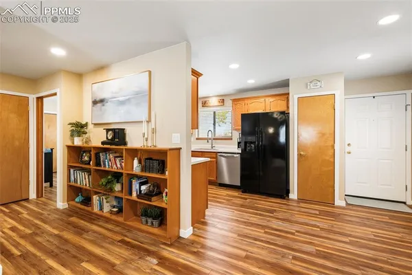 a kitchen with stainless steel appliances a refrigerator and a wooden floor
