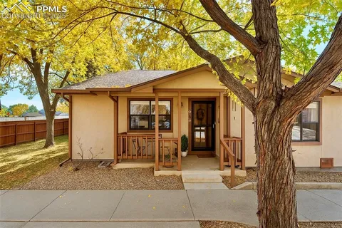 a porch with table and chairs under an umbrella