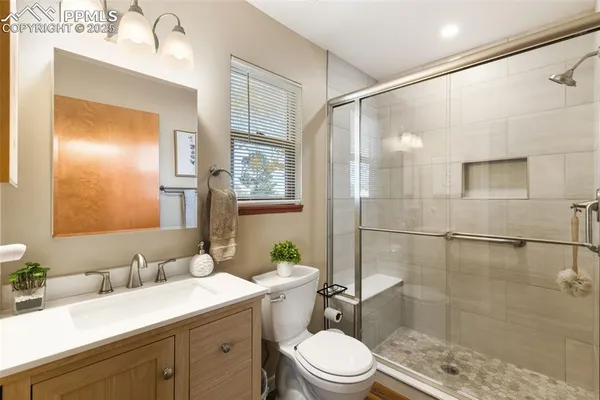 a bathroom with a sink a toilet and shower
