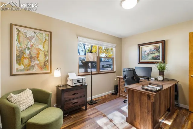 a view of a workspace with furniture and a window