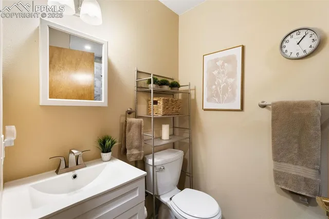 a bathroom with a sink vanity mirror and toilet