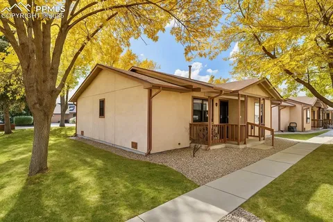 a view of a yard in front of a house with a tree