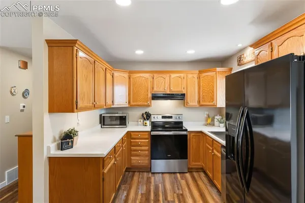 a kitchen with stainless steel appliances granite countertop a refrigerator a stove top oven a sink and dishwasher